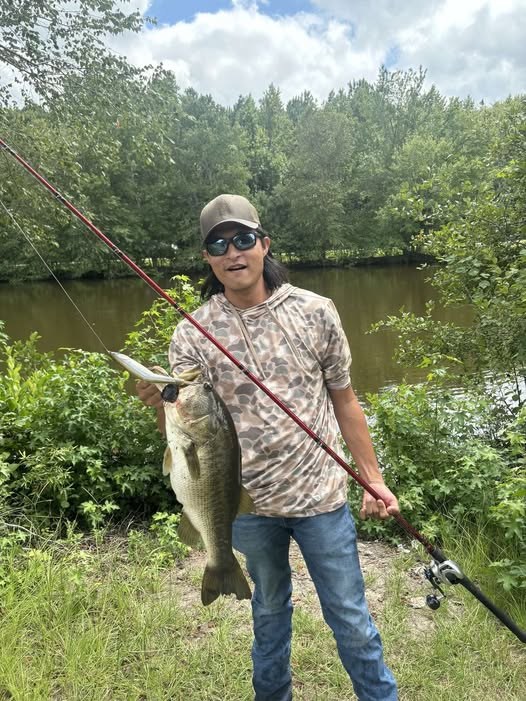 An angler holding a big Falls Lake largemouth bass caught on a glide bait